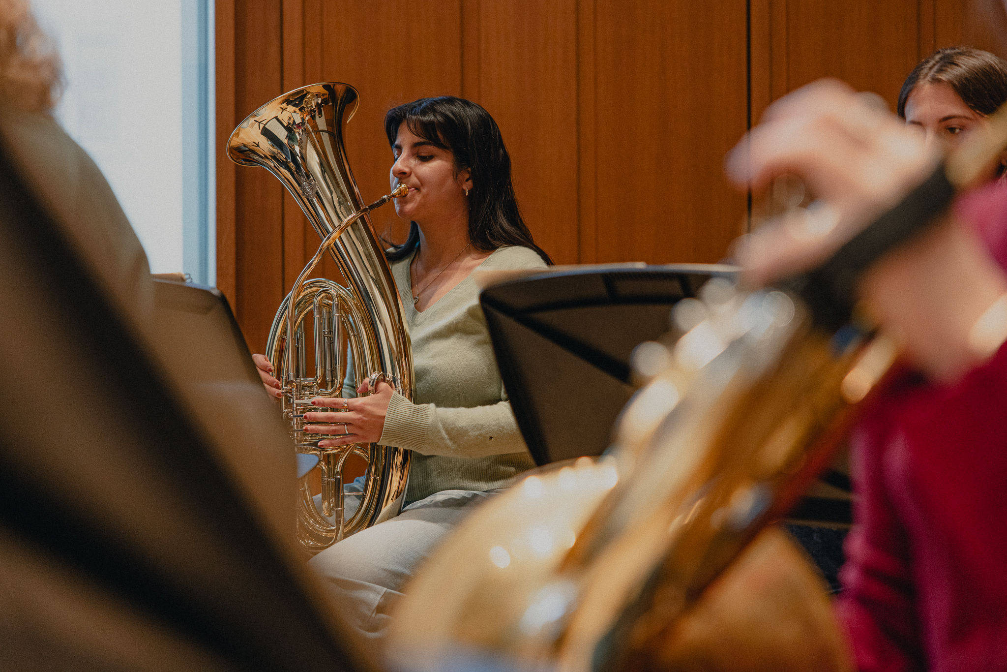 young woman with brown hair playing a tuba