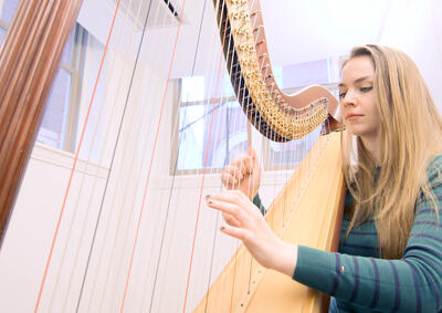 Student playing harp